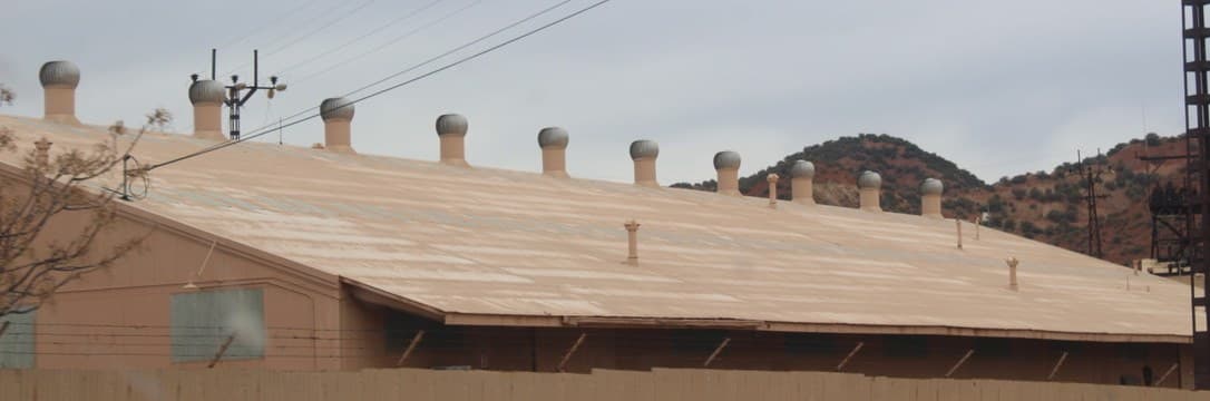 A row of roof cyclones along the ridge of a large industrial building